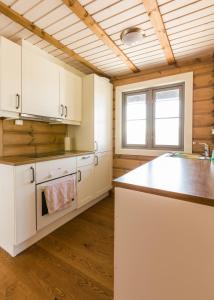 uma cozinha com armários brancos e uma bancada em Gladheim em Stranda