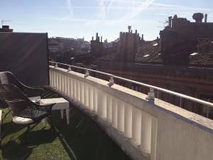 um banco sentado numa varanda com vista para a cidade em Hotel Ours Blanc - Wilson em Toulouse