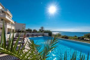 a swimming pool with a view of the ocean at Villa Jurac in Povljana
