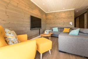 un soggiorno con un divano e una televisione di Lastølen 3 bedrooms a Brunstad