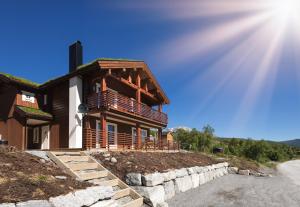una casa sul ciglio di una strada con il sole di Lastølen 3 bedrooms a Brunstad Altre 3 foto