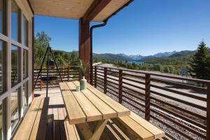 a wooden bench on a balcony with a view of the mountains at Lastølen 3 bedrooms in Brunstad
