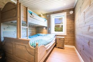 a bedroom with a bunk bed in a wooden cabin at Lastølen 3 bedrooms in Brunstad