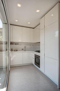 Oliveto Lario的住宿－Villa Sara Lakeside，白色的厨房配有白色橱柜和炉灶。