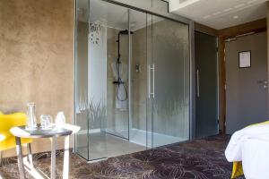 a glass shower in a room with a table at Hotel Restaurant L'Orchidee in Ensisheim +80 photos