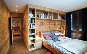 een slaapkamer met een bed en boekenplanken bij chesa la posta in Samedan