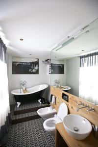 een badkamer met 2 toiletten en een bad bij chesa la posta in Samedan +3 foto's