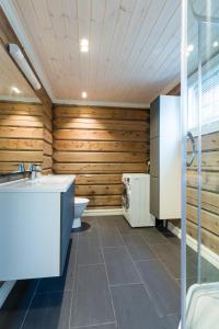 BrunstadにあるLake View Apartment 4 bedroomsのバスルーム(木製の壁、トイレ、洗面台付)