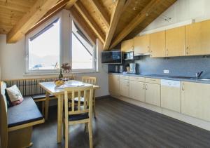 a kitchen with a table and a dining room at Apart Haus Bernardes in Fiss