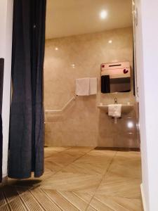 a bathroom with a sink and a towel dispenser at Hôtel Résidence De Bruxelles in Paris