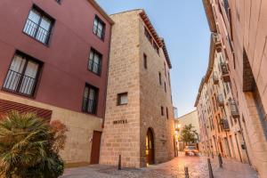 a brick building on a street next to buildings at Eurostars Fuerte Ruavieja in Logroño