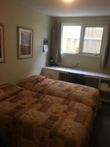 a bedroom with a large bed and a window at Laura's Lodge in Saskatoon