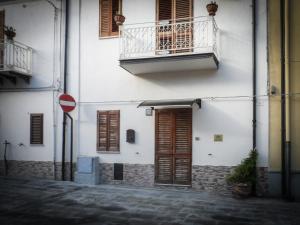 een wit gebouw met een balkon en een deur bij Guest House a Portapalermo in Santo Stefano di Camastra