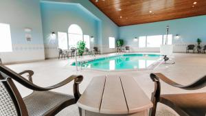 a pool in a room with chairs and a table at Van Buren Hotel in Shipshewana