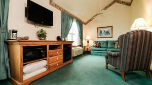 a living room with a television and a couch at Van Buren Hotel in Shipshewana