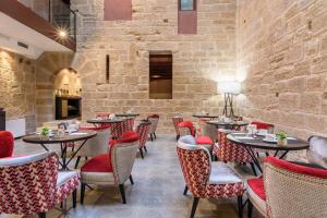 un restaurante con mesas y sillas y una pared de piedra en Eurostars Fuerte Ruavieja en Logroño