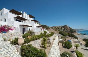 a row of white houses on a hill next to the ocean at Kionia Apartments in Kerames