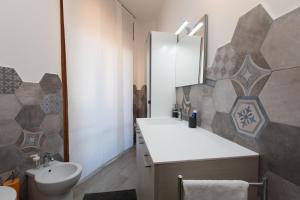 ein Badezimmer mit einem Waschbecken, einem WC und einem Spiegel in der Unterkunft Salerno e le due coste in Salerno