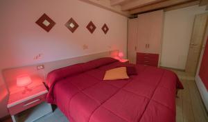 a bedroom with a red bed with a red comforter at Chalet Val Concei in Lenzumo di Concei +39 photos