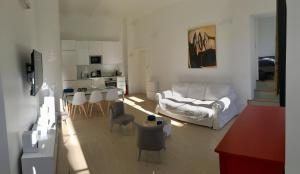a living room with a white couch and a kitchen at Apartment on Place Massena in Nice