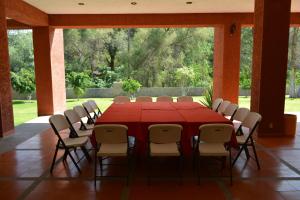 una sala de conferencias con mesa roja y sillas en Lourdes Hotel Campestre, en Santa María del Río