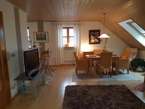 a living room with a television and a dining room at Just like home in Erding