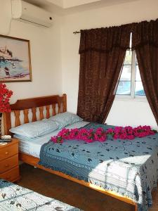 - une chambre avec un lit orné de fleurs roses dans l'établissement Hotel Contadora, à Contadora