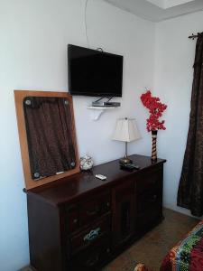 a room with a dresser with a television on a wall at Hotel Contadora in Contadora