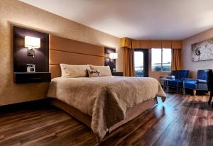 ノースバンクーバーにあるザ ロンズデール キー ホテルのベッド、デスク、椅子が備わるホテルルームです。