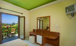 a bathroom with a sink and a mirror and a balcony at Castello Rosso Hotel in Nea Stira