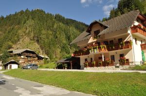 a building with flowers on the balconies on a mountain at Prenočišča Valentina in Solčava