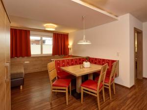 a dining room with a table and red chairs at SöldenLiving Appartements in Sölden