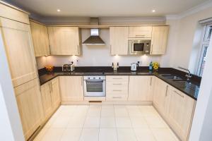 
a kitchen with white cabinets and white appliances at Jade - Royal Swan Quarter in Leatherhead
