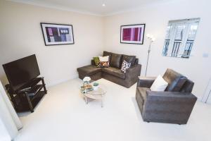 
a living room filled with furniture and a tv at Jade - Royal Swan Quarter in Leatherhead

