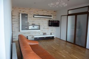 a living room with a couch and a brick wall at Grand View Apartment in Braşov
