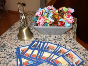 un tavolo con una ciotola di caramelle e un campanello di Hotel Iride stazione Lambrate Città studi a Milano