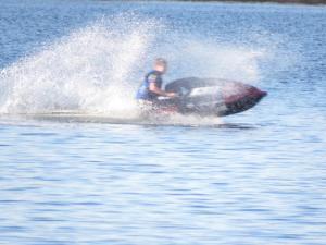 un hombre en una moto acuática en el agua en Cabañas del Dique Frente al Lago, en Villa del Dique