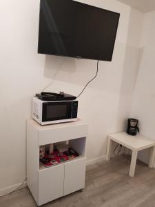 einen Fernseher auf einer Mikrowelle auf einem Stand in der Unterkunft Appart Lille Centre in Lille