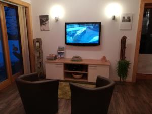 ein Wohnzimmer mit 2 Stühlen und einem Flachbild-TV in der Unterkunft Chalet Rasnerhof in Hopfgarten in Defereggen