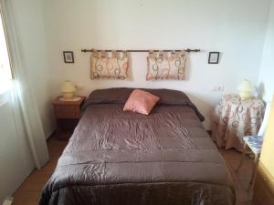 1 dormitorio con 1 cama con edredón marrón en Vivienda Rural El Mirador de Enix, en Enix