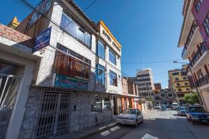 a building on a street with a car parked in front at Hotel Galaxia in Huaraz
