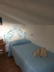 a bedroom with a blue bed with two towels on it at Casa Gallo in Santa Marinella