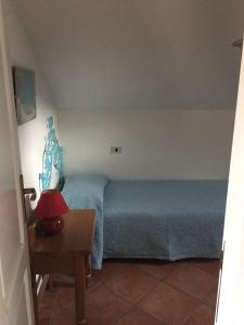 a bedroom with a bed and a table with a lamp at Casa Gallo in Santa Marinella