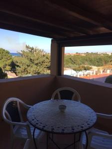 a table and chairs on a balcony with two windows at Casa Gallo in Santa Marinella