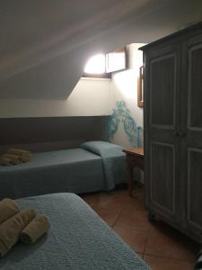 a bedroom with two beds and a cabinet and a table at Casa Gallo in Santa Marinella