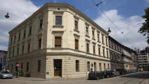 a large white building with cars parked in front of it at Apartament krakowski GIMO na Kazimierzu in Krakow