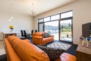 a living room with an orange couch and a table at Central Park Apartments in Cromwell