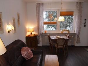 a living room with a couch and a table and a window at Ferienwohnung Schüler-Wolke 2 in Sankt Andreasberg