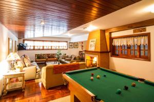 Una sala de estar con una mesa de billar. en Pousada Serena, en Campos do Jordão