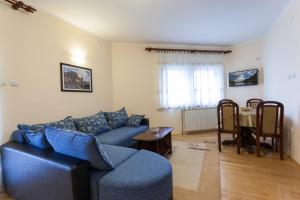 ein Wohnzimmer mit einem blauen Sofa und einem Tisch in der Unterkunft Vila Zlatiborski biser in Zlatibor